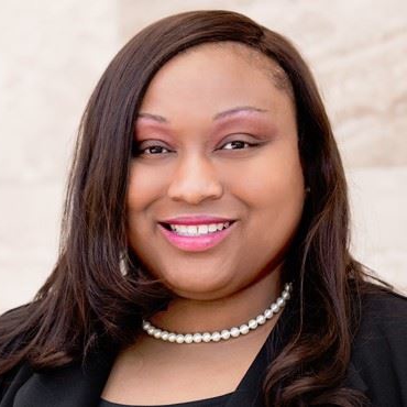Jessica Horace, family law attorney at Bryan Fagan, PLLC, smiling with a professional appearance, wearing a pearl necklace and a black blazer, in a soft-focus background.